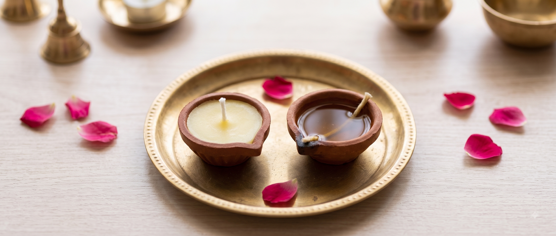 A cow ghee diya and a traditional oil diya placed side by side for comparison during puja preparation
