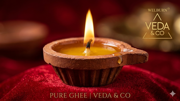 Glowing cow ghee diya illuminating a peaceful home meditation and puja corner — Veda & Co