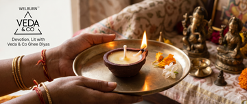 A Veda & Co cow ghee clay diya being used for aarti — steady golden flame — Veda & Co