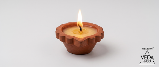 A single cow ghee diya burning with a steady flame on a neutral background