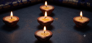Rows of clay cow ghee diyas arranged for community lighting at a temple