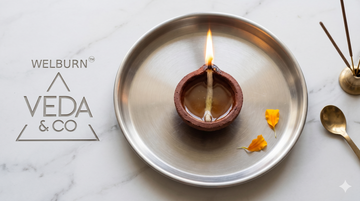 A correctly placed and lit diya for pooja on a clean home altar — Veda & Co