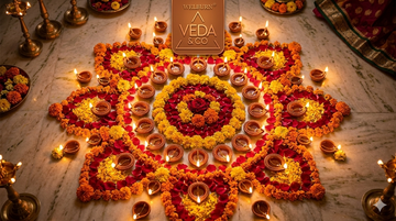 Rows of lit ghee diyas arranged in a decorative pattern on a Diwali-decorated floor — Veda & Co
