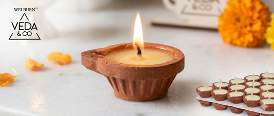 Single clay ghee diya burning with a clean steady flame and minimal smoke in a home puja room